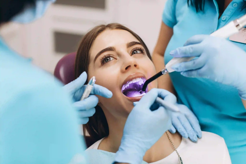 Dentist performing an ultraviolet teeth whitening treatment on a patient in a modern dental clinic